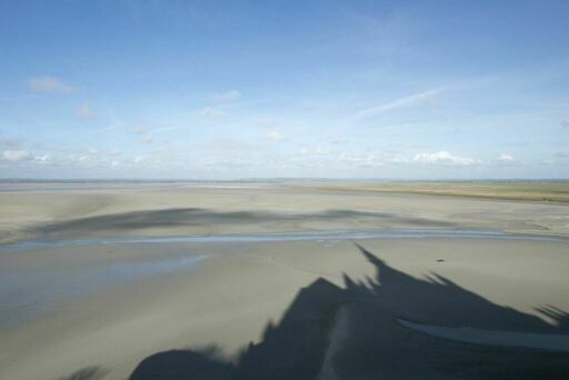 Ombre de l'abbaye du Mont-Saint-Michel sur le sable de la baie